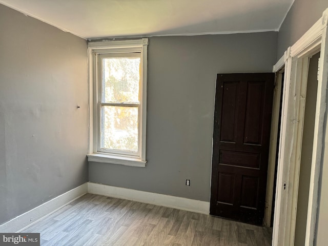 unfurnished bedroom with crown molding, wood finished floors, and baseboards