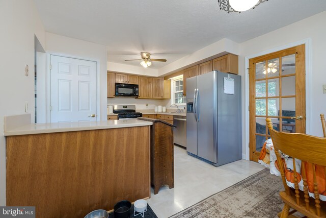 kitchen featuring stainless steel appliances, kitchen peninsula, sink, and ceiling fan