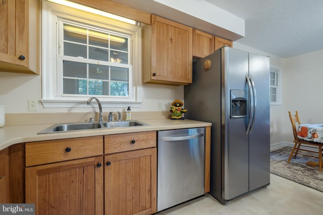 kitchen featuring a textured ceiling, appliances with stainless steel finishes, and sink