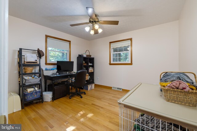 office area featuring ceiling fan, wood-type flooring, and a textured ceiling