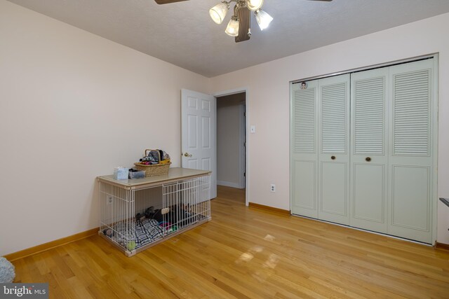 interior space with a closet, hardwood / wood-style floors, a textured ceiling, and ceiling fan