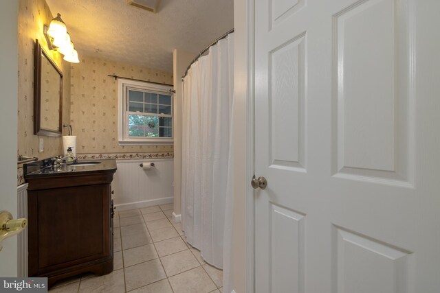 bathroom featuring tile patterned floors, vanity, and a textured ceiling