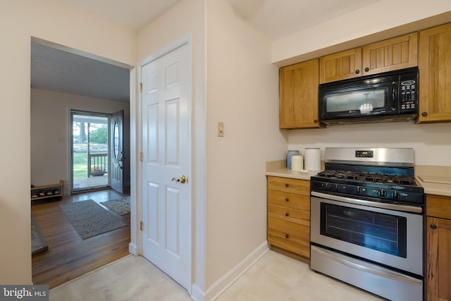 kitchen with stainless steel gas range and light hardwood / wood-style flooring