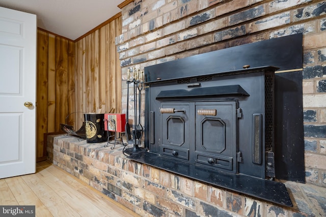 interior details with wood walls, hardwood / wood-style floors, and a wood stove