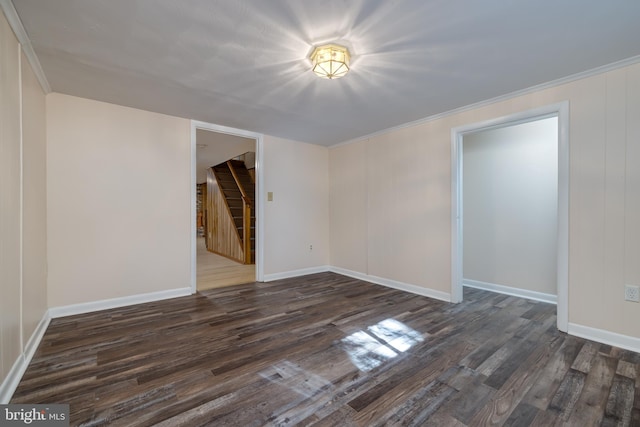 spare room featuring crown molding and dark hardwood / wood-style flooring