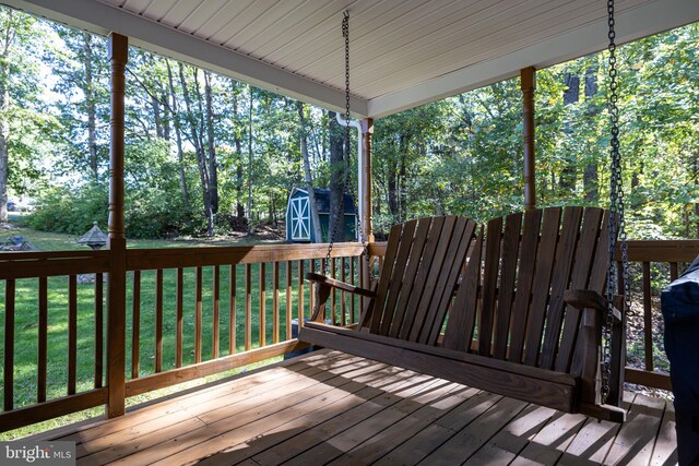 deck featuring a storage unit and a lawn