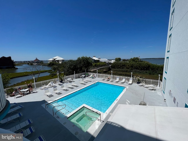 view of swimming pool with a water view and a patio