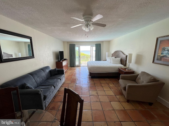 bedroom featuring ceiling fan, a textured ceiling, tile patterned flooring, and access to outside