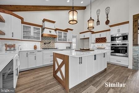 kitchen featuring beam ceiling, white cabinets, tasteful backsplash, and hanging light fixtures