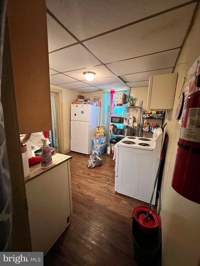 kitchen featuring a drop ceiling, white appliances, wood-type flooring, and white cabinets