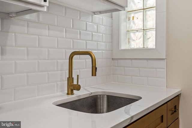 room details featuring light stone counters and sink