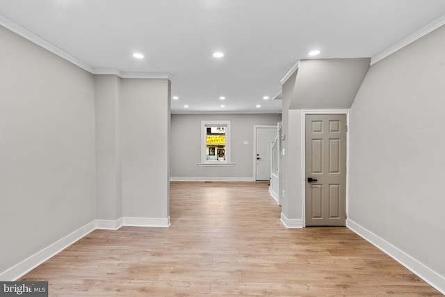 hall with ornamental molding and light hardwood / wood-style flooring