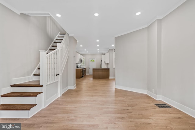 staircase featuring hardwood / wood-style flooring and crown molding