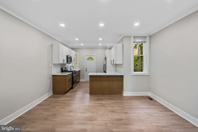 kitchen featuring kitchen peninsula, light hardwood / wood-style floors, stainless steel appliances, and white cabinets