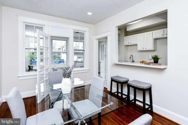 dining space featuring sink and dark hardwood / wood-style flooring