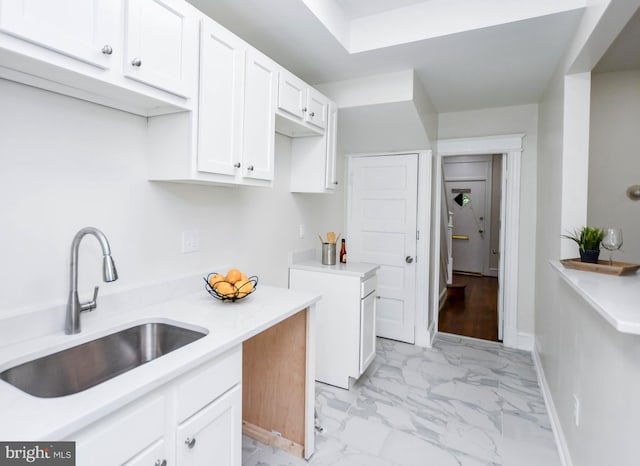 kitchen featuring white cabinetry and sink