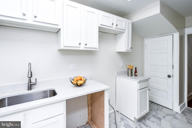 kitchen featuring sink and white cabinets