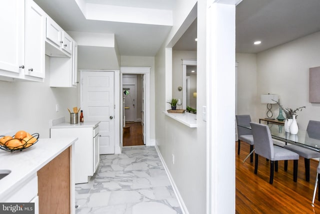 kitchen with light wood-type flooring and white cabinetry