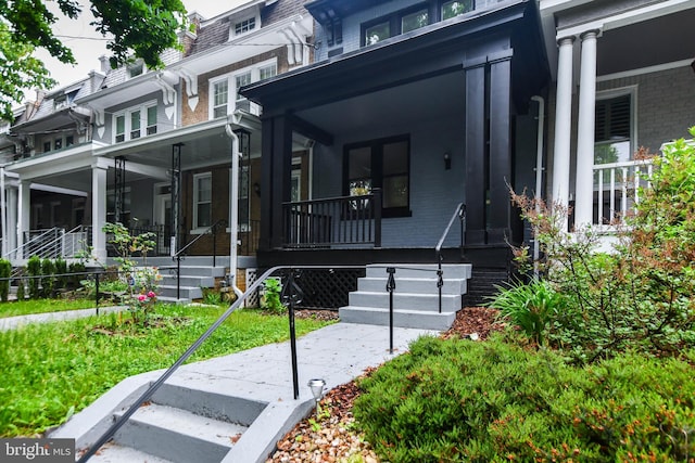 view of front of property featuring a porch, a front yard, and a sunroom