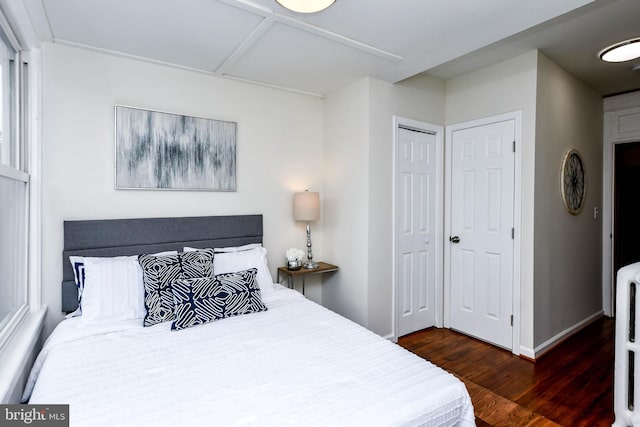 bedroom with dark hardwood / wood-style flooring