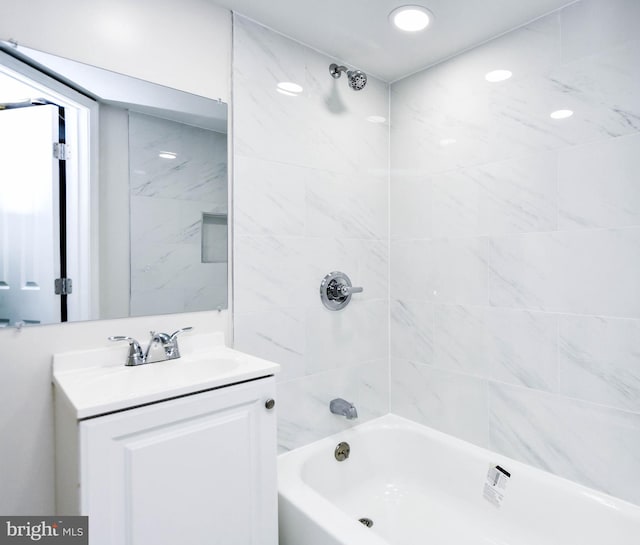 bathroom featuring tiled shower / bath combo and vanity