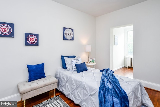 bedroom with hardwood / wood-style floors and radiator heating unit