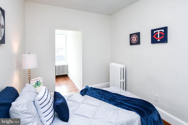 bedroom featuring hardwood / wood-style flooring and radiator heating unit