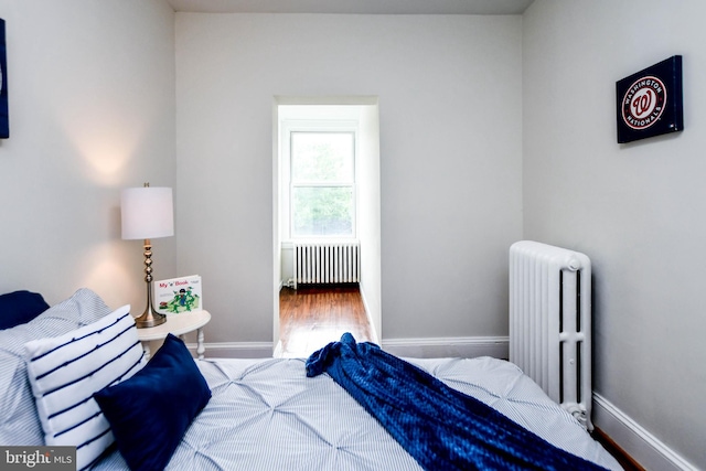 bedroom featuring wood-type flooring and radiator heating unit