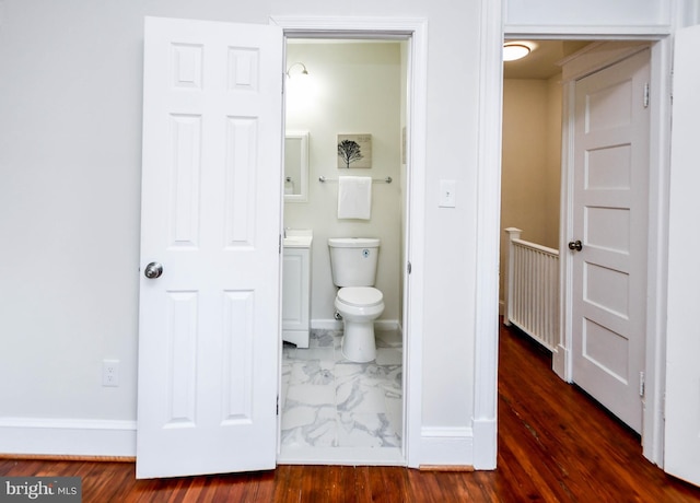 bathroom with hardwood / wood-style flooring and toilet