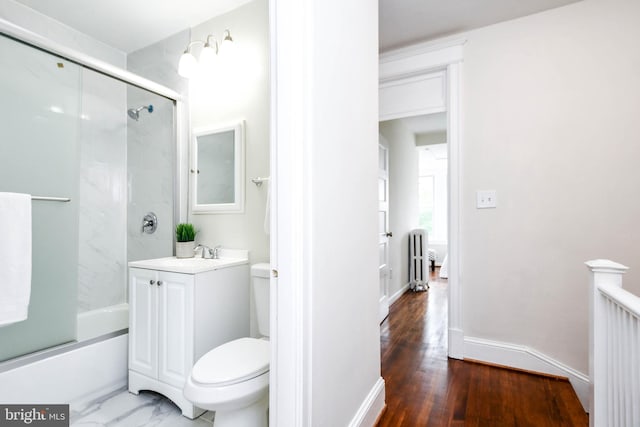 full bathroom featuring toilet, bath / shower combo with glass door, vanity, and wood-type flooring