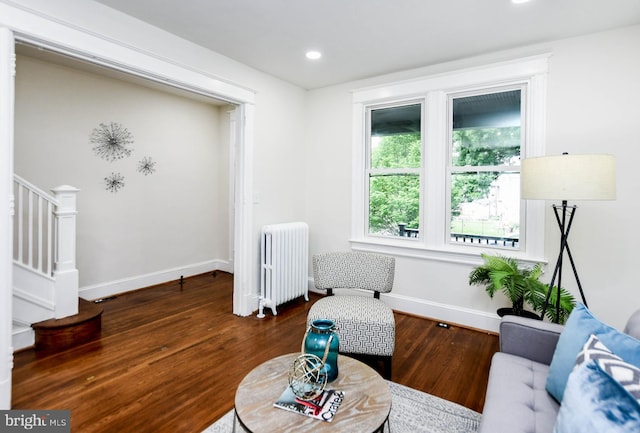 living area with dark hardwood / wood-style flooring and radiator