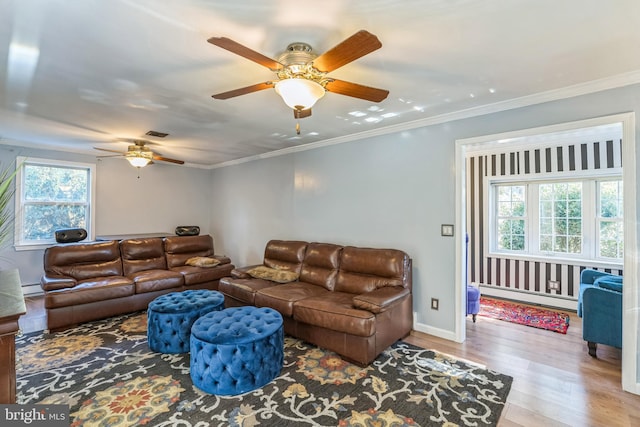 living room with ceiling fan, plenty of natural light, light wood-type flooring, and a baseboard heating unit