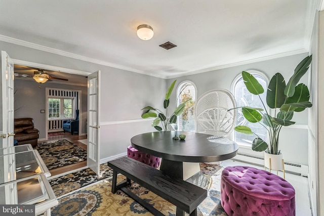 dining room featuring ceiling fan, baseboard heating, hardwood / wood-style floors, crown molding, and french doors