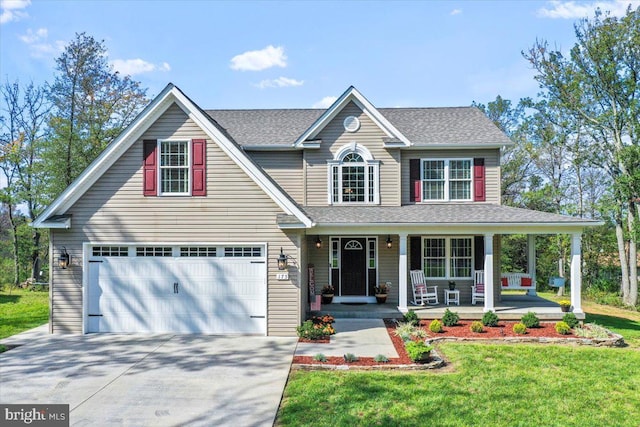 view of front of property featuring a garage, covered porch, and a front yard