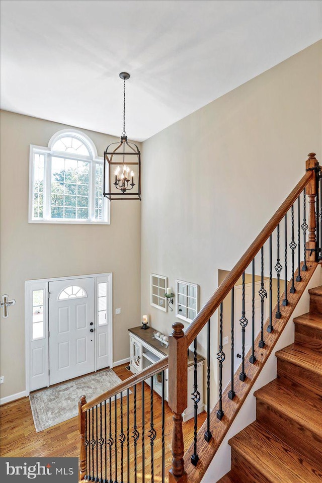 entrance foyer with a notable chandelier and hardwood / wood-style flooring