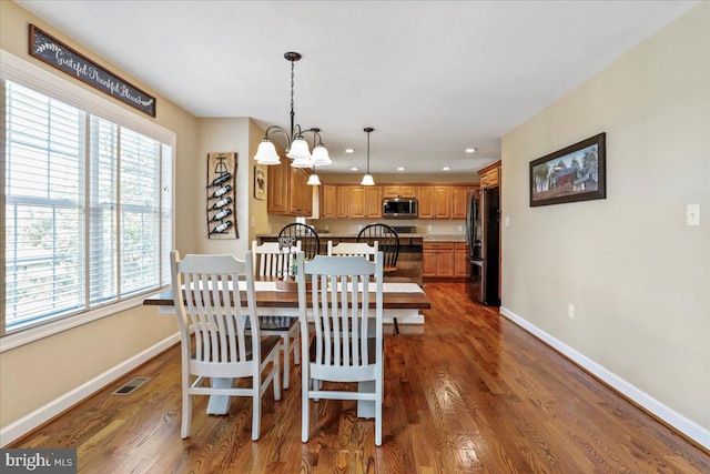 dining room featuring dark hardwood / wood-style flooring and a notable chandelier