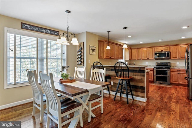 dining room with dark wood-type flooring and a notable chandelier