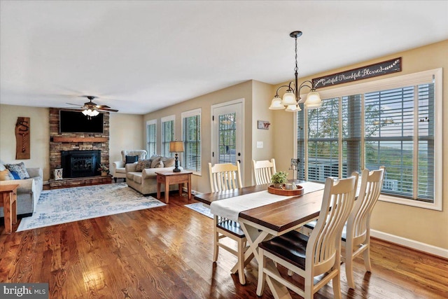 dining area with wood-type flooring, ceiling fan with notable chandelier, and plenty of natural light