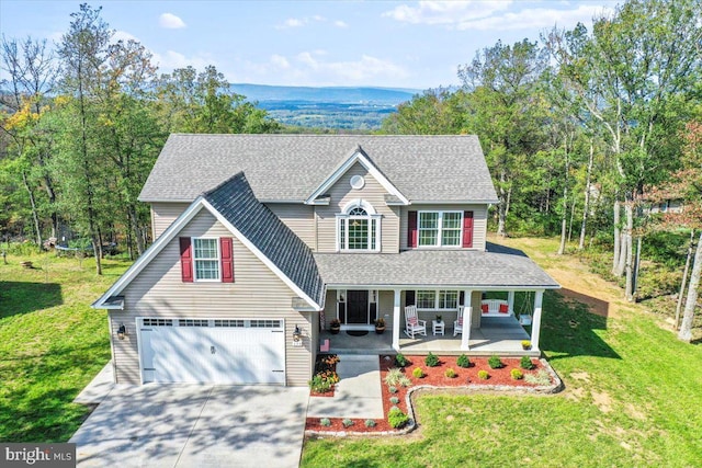 view of front of home featuring a front lawn, a garage, and covered porch