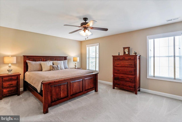 bedroom with multiple windows and light carpet