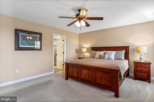 bedroom with light colored carpet, ceiling fan, and ensuite bathroom