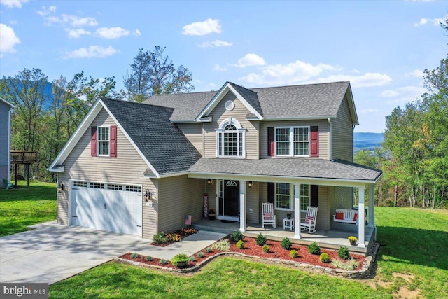 view of front of property featuring a front yard, covered porch, and a garage