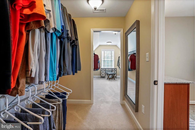 spacious closet featuring lofted ceiling and light carpet