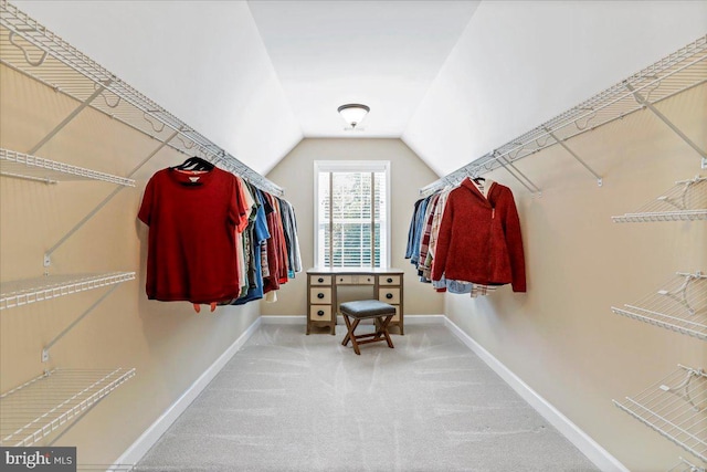 spacious closet featuring lofted ceiling and carpet floors