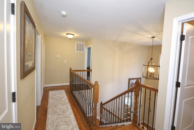 corridor featuring hardwood / wood-style floors and a chandelier