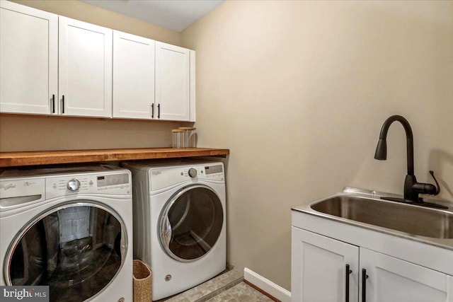 laundry area featuring cabinets, light tile patterned flooring, sink, and washer and dryer