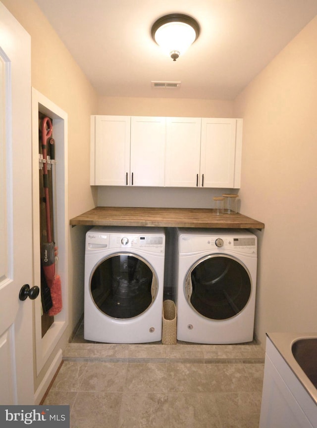 laundry area with cabinets, light tile patterned floors, and independent washer and dryer