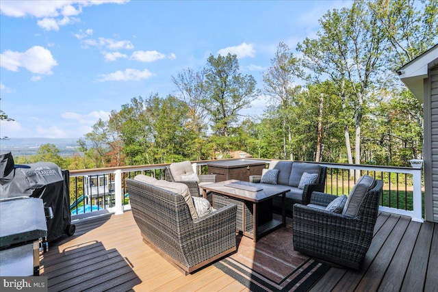 wooden deck with an outdoor living space with a fire pit and a hot tub