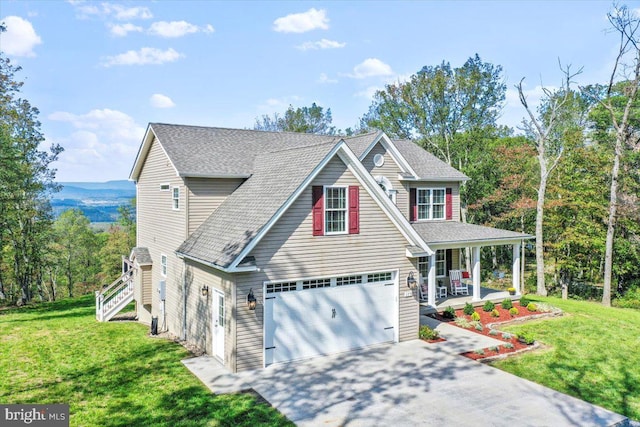 view of front of home with a front yard, a garage, and covered porch