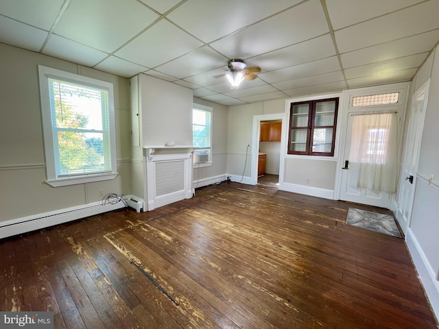 interior space featuring a drop ceiling, ceiling fan, dark hardwood / wood-style floors, and a healthy amount of sunlight